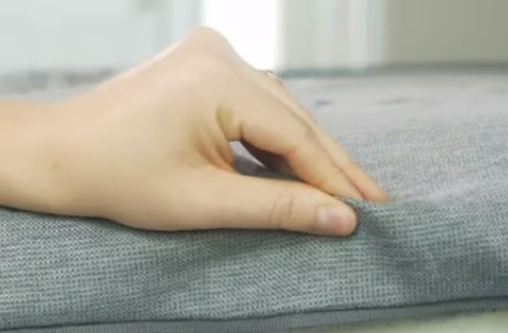 Inspecting how soft and durable the cover of the mattress topper