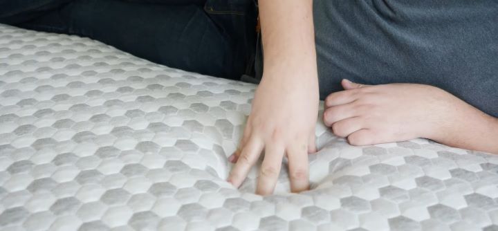 A tester checking the softness and comfortability of the mattress topper