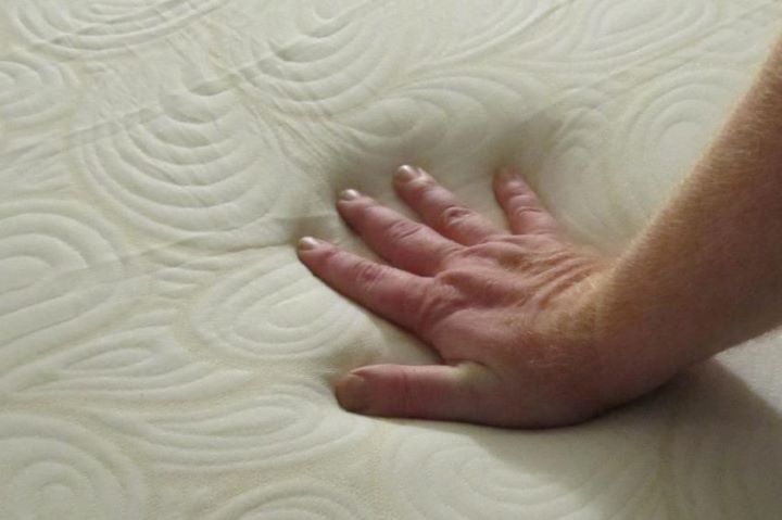 Checking the firmness of the mattress for shoulder pain